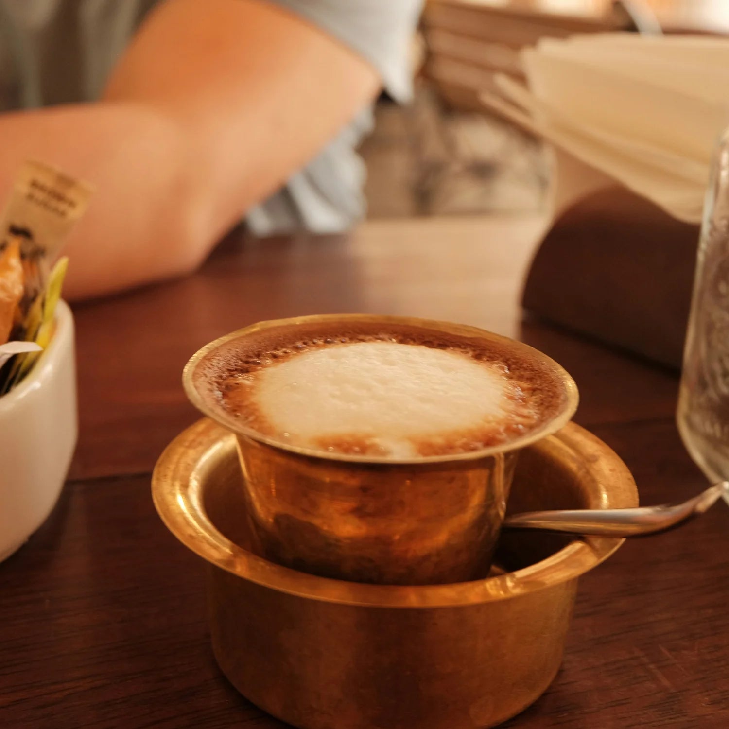 Cup of coffee in a brass holder on a wooden table